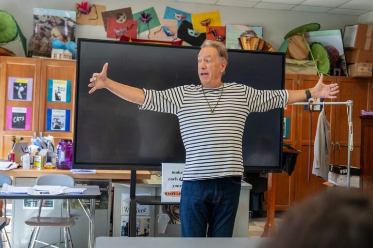 David Gonzalez addressing students with outstretched arms during a McCaskey High School classroom visit in Lancaster