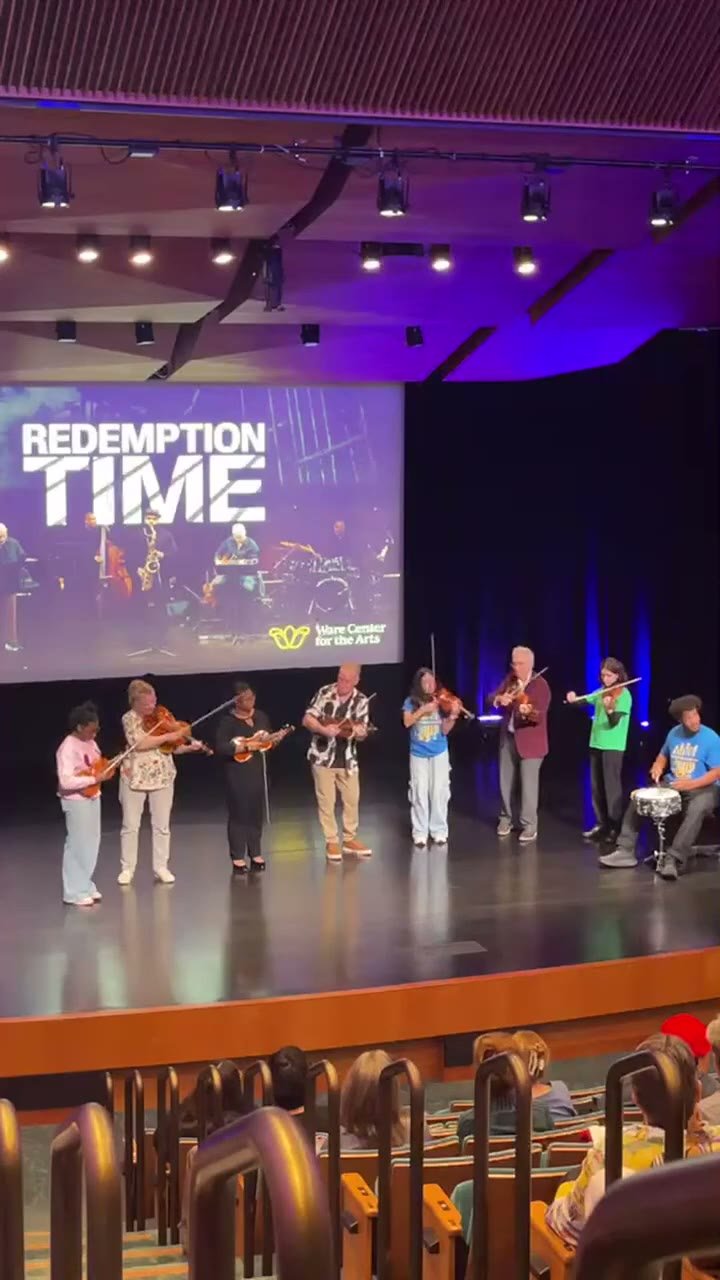Christian Howes and student musicians performing together onstage at the Ware Center